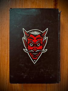 Devil Sticker on old black book