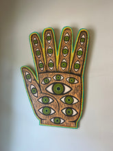 Load image into Gallery viewer, Decorative wall art in the shape of a hand with eye patterns on a plain background