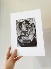 Load image into Gallery viewer, Hand holding a print of a black and white linocut illustration of woman singing against a light background